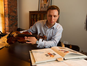 Man appraising a violin